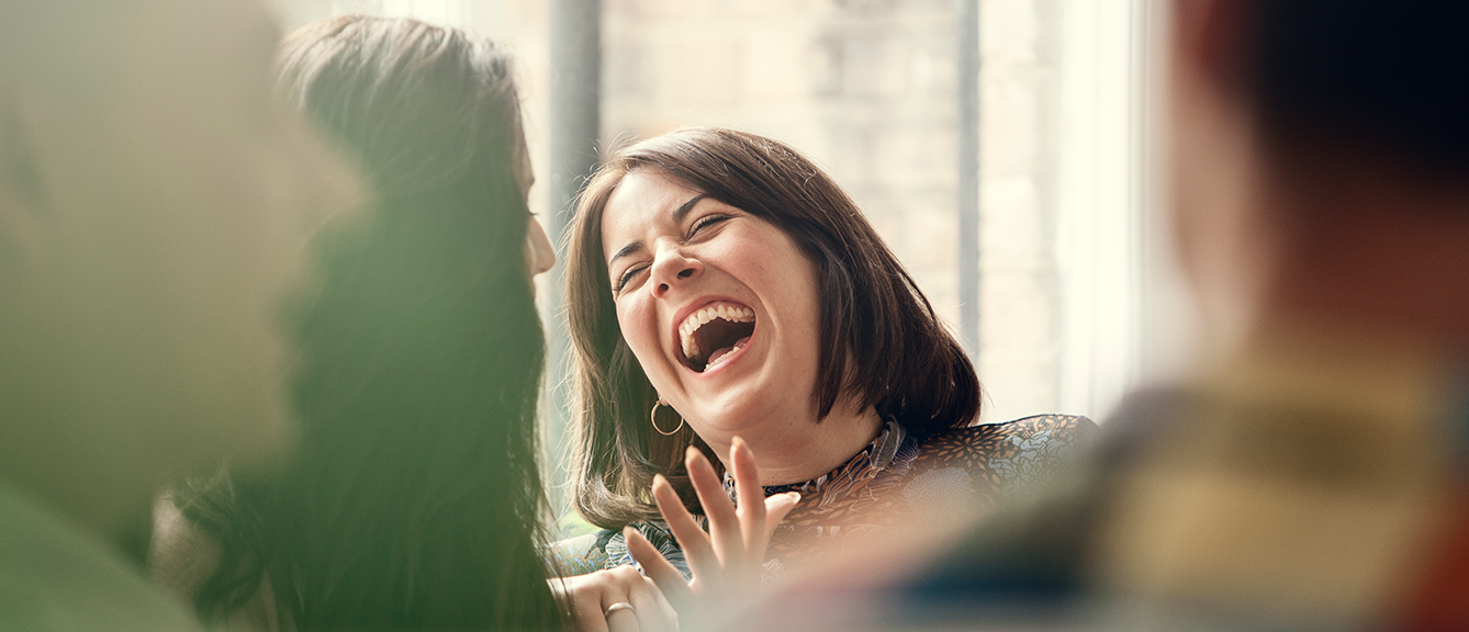 Woman laughing in a crowd